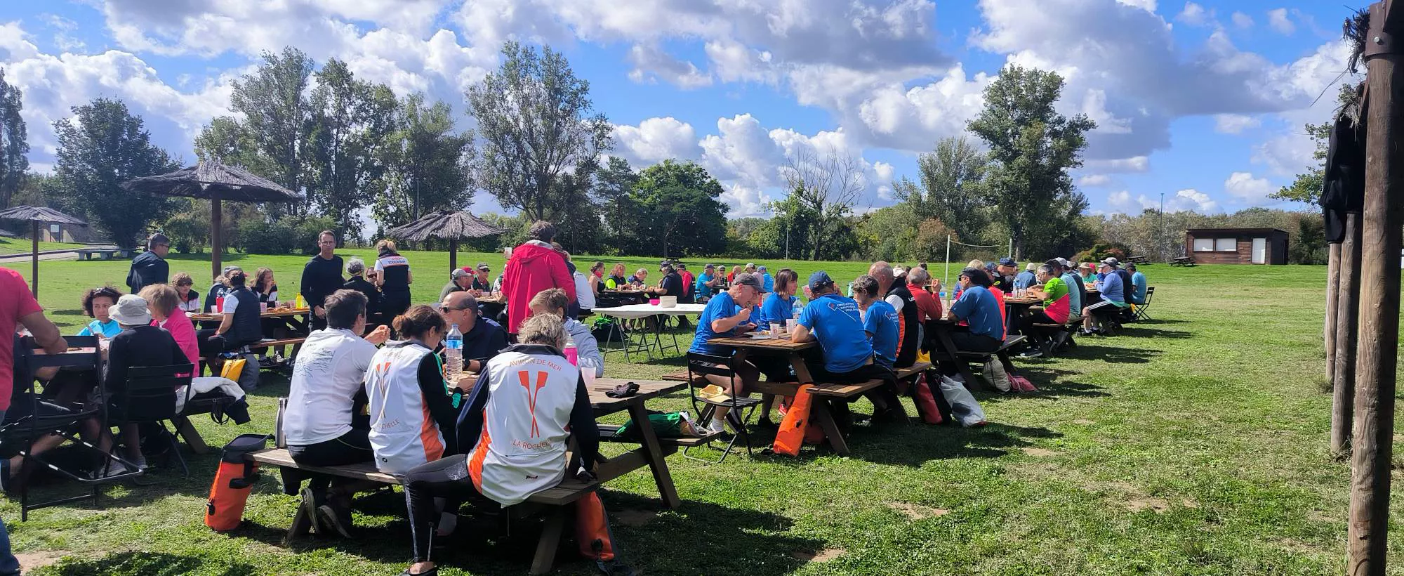 Rameurs de plusieurs clubs réunis pour le déjeuner sur l'herbe pendant une randonnée d'aviron